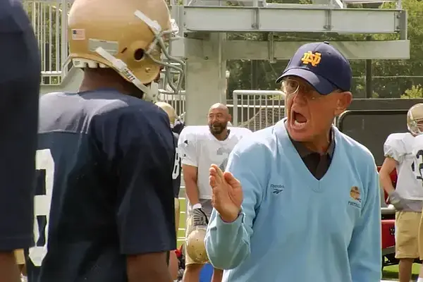 Coach gestures and yells at a player during Notre Dame football practice.